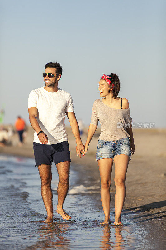 沿着海岸散步的年轻夫妇