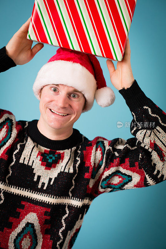 男人戴着圣诞帽和丑陋的毛衣拿着圣诞礼物