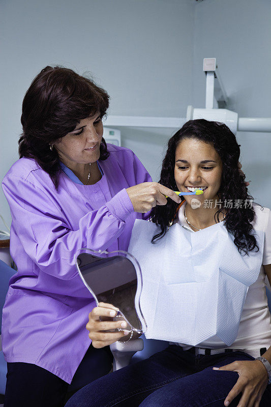 牙医教年轻女病人使用牙刷的技巧