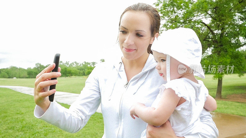 年轻妈妈抱着宝宝用手机自拍