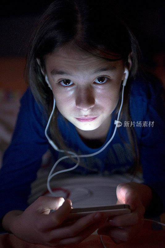 十几岁的女孩在用手机听音乐