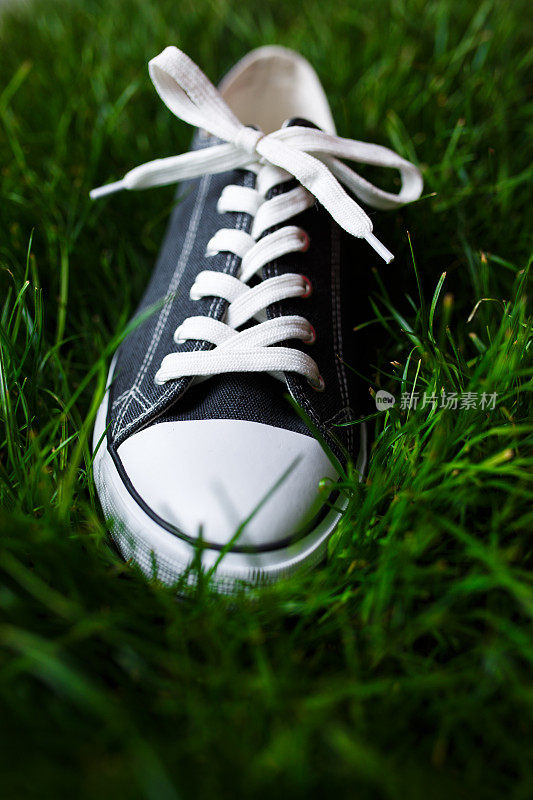 新球鞋在新鲜的草地上的特写