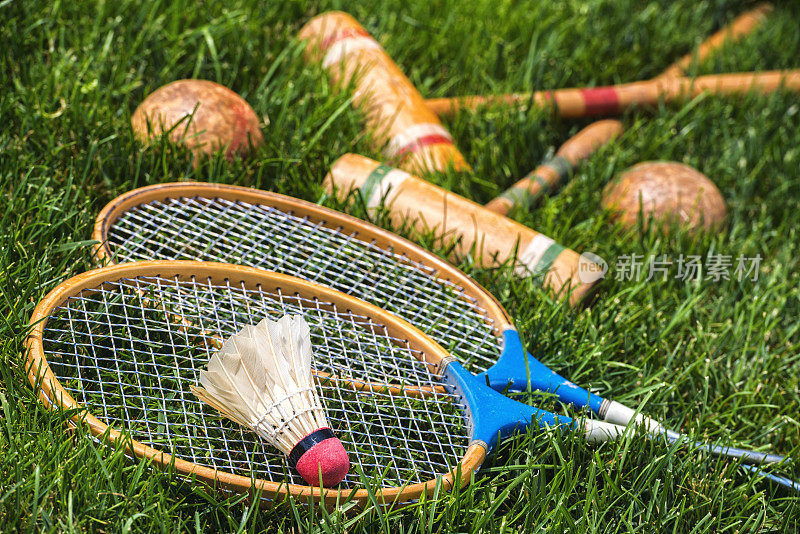 草地上躺着老式羽毛球拍和槌球