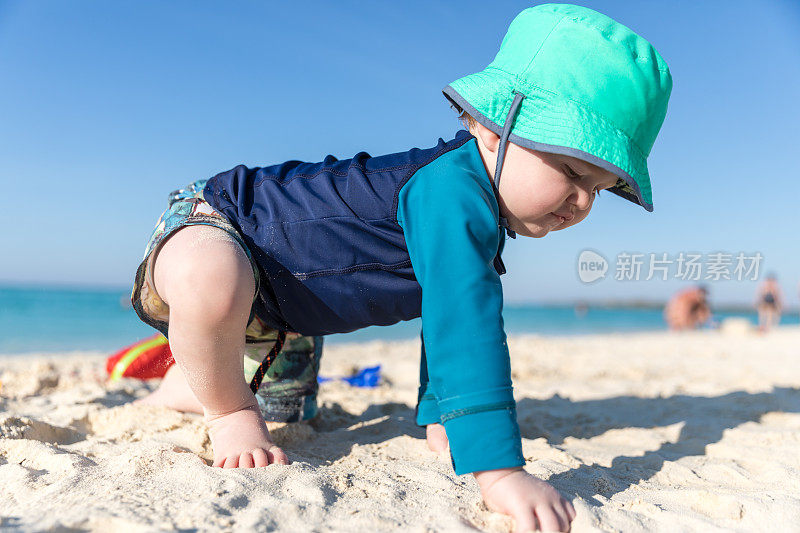 在古巴卡约可可热带海滩上爬行的小男孩