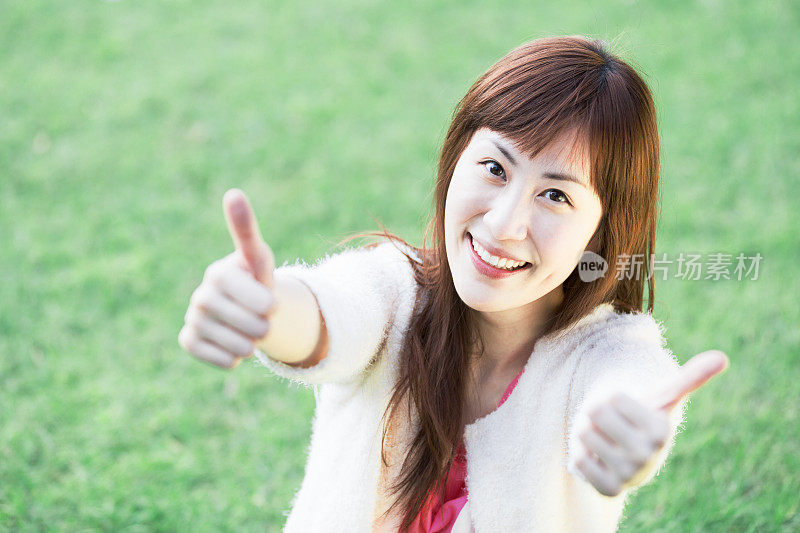 快乐的亚洲女孩竖起大拇指