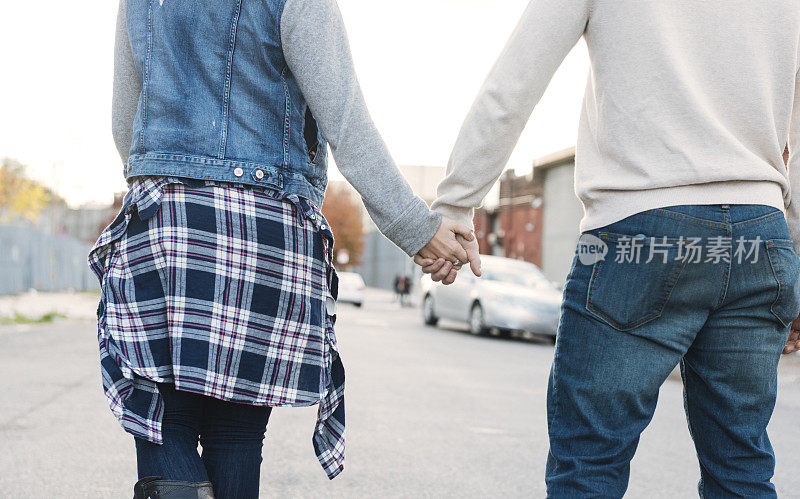一对相爱的年轻夫妇在纽约布鲁克林牵着手散步