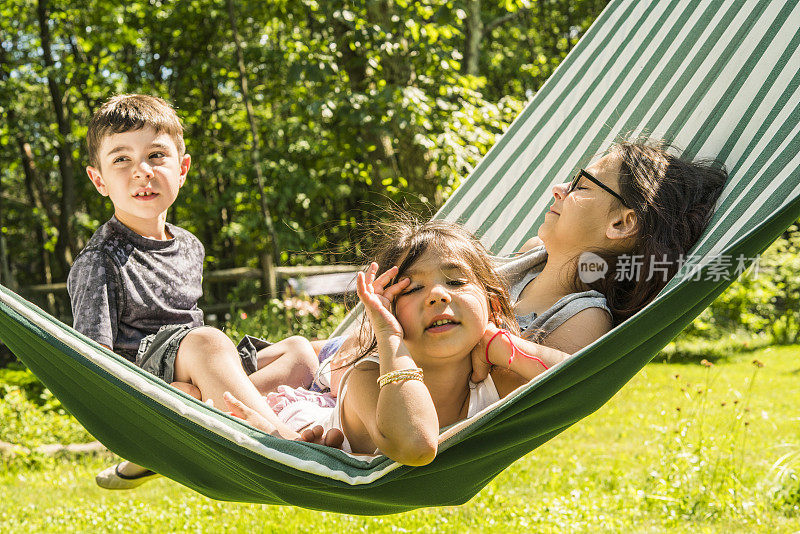 三个孩子，小女孩，小男孩和少女，兄弟姐妹，在吊床上玩耍