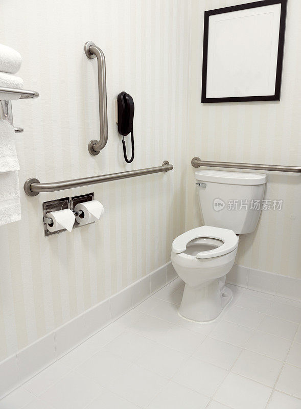 白色浴室，马桶周围有残疾人专用栏杆