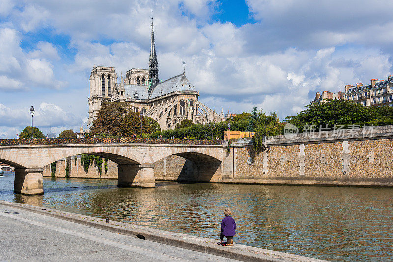 一个女人望着塞纳河对岸的巴黎圣母院