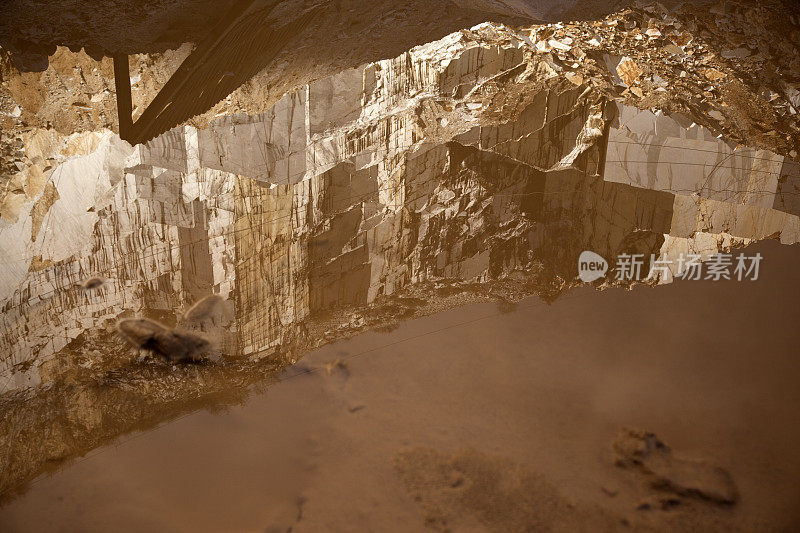 映照着雄伟大理石采石场的肮脏水坑。意大利。
