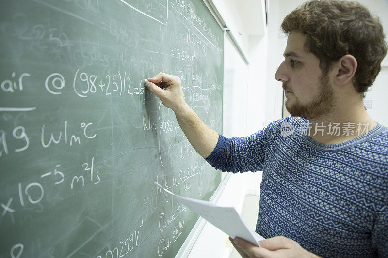 男生在黑板前写数学公式