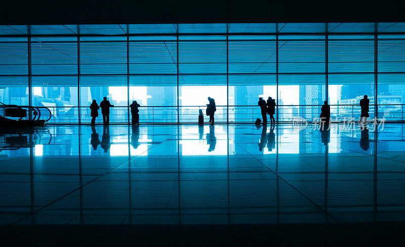 游客们走在现代化的机场走廊上