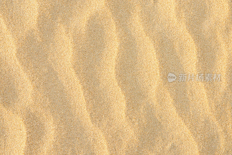 黄金海岸细沙背景。波纹纹理柔和的颜色太阳耀斑。空副本空间。热带度假休闲概念