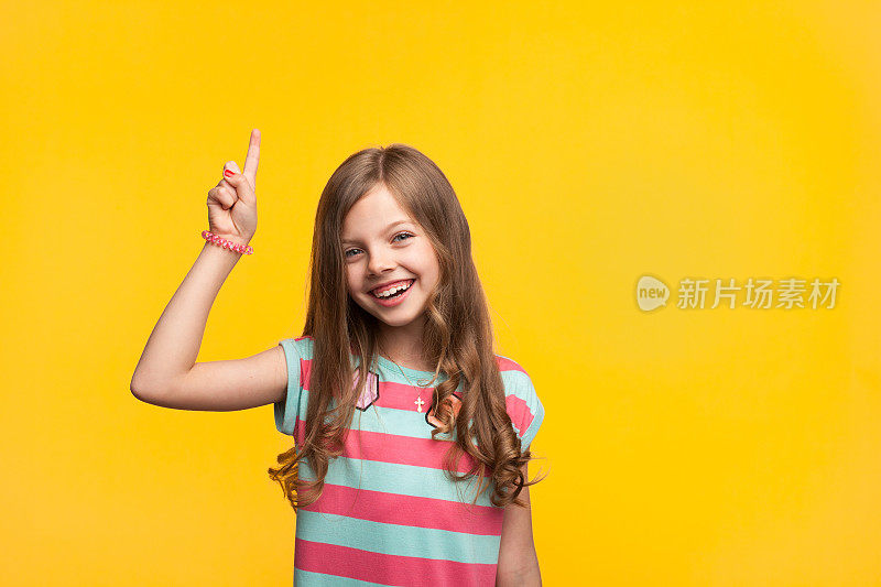 快乐的小女孩指着橙色
