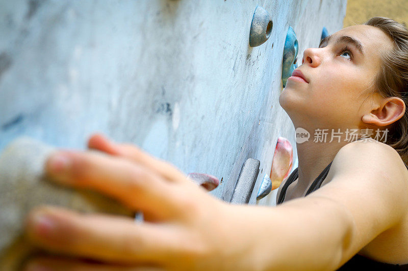 十几岁的男孩在室内攀岩墙上训练攀岩