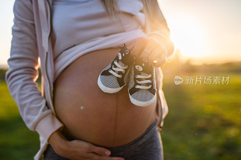 特写孕妇的婴儿鞋。