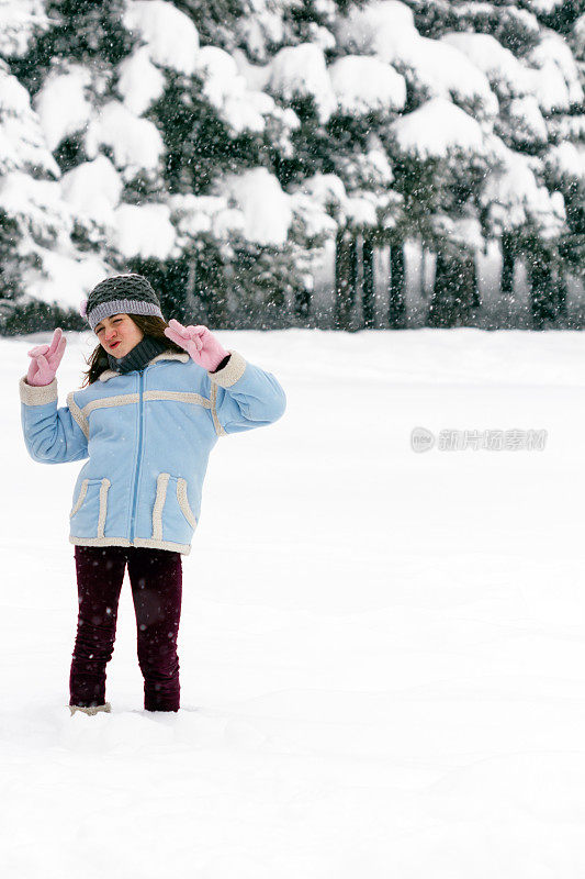 冬天可爱的女孩在雪地里玩得很开心