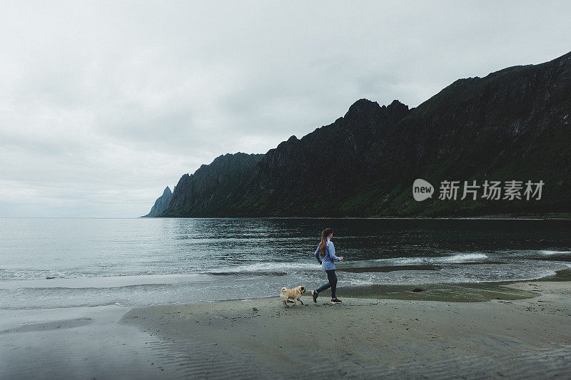 在挪威，一个女人带着狗在雨中奔跑