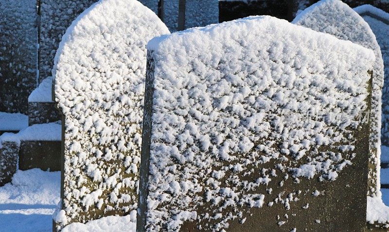 白雪覆盖的墓地里的坟墓、墓碑和墓碑