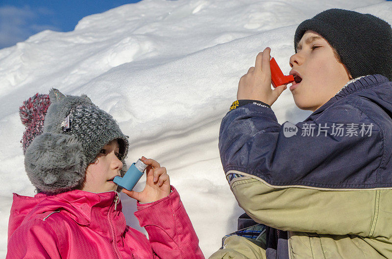 小男孩和女孩在铲雪后使用哮喘泵