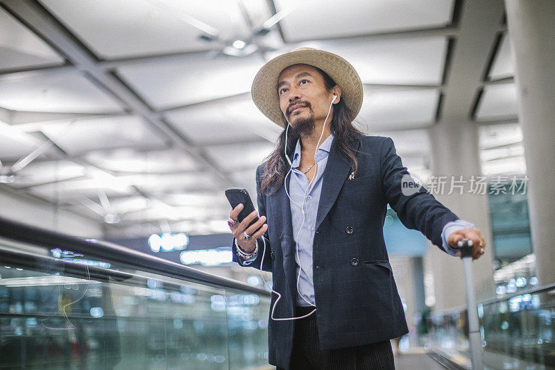 一个成熟的男人在机场使用手机