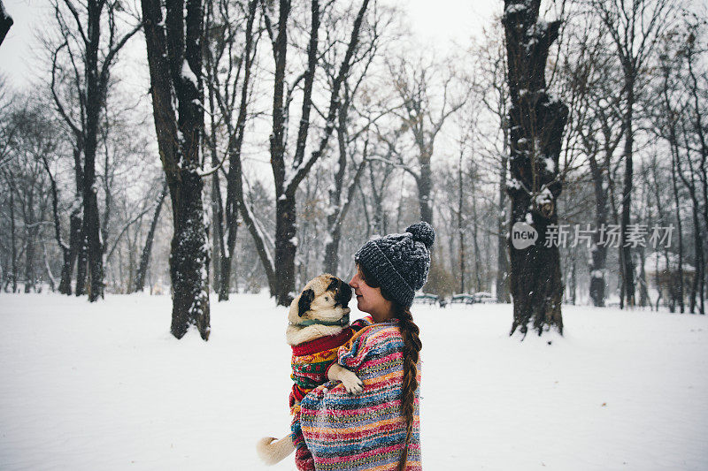 女人和狗在冬季假期享受雪