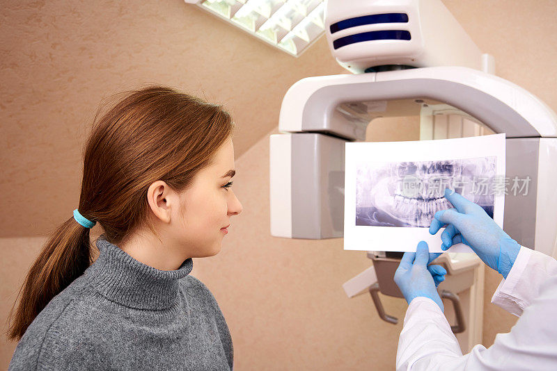牙科医生在牙科诊所给病人看x光片。牙科计算机断层摄影。