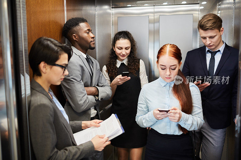 一群在电梯里打电话的上班族