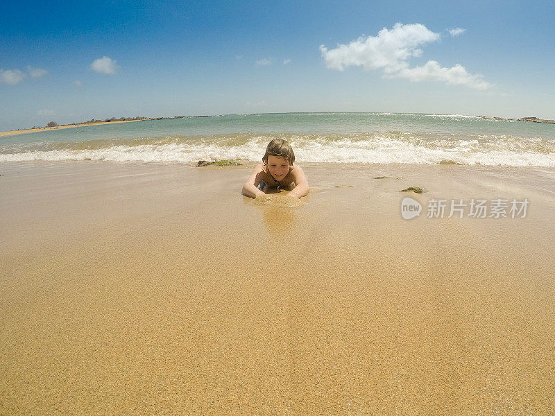 在天堂里游泳，孩子们在考艾岛的海洋里游泳，在荒芜的海滩上玩耍