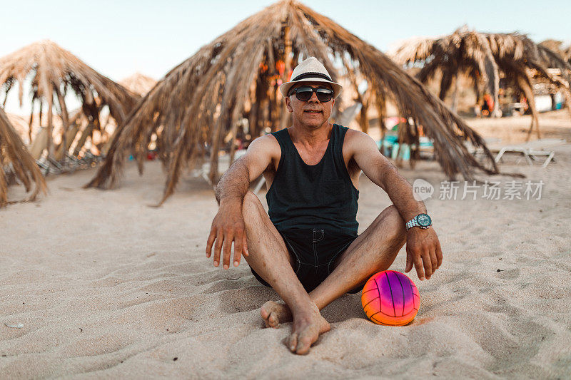 一个成熟的男人在一个阳光明媚的夏日的海滩上放松