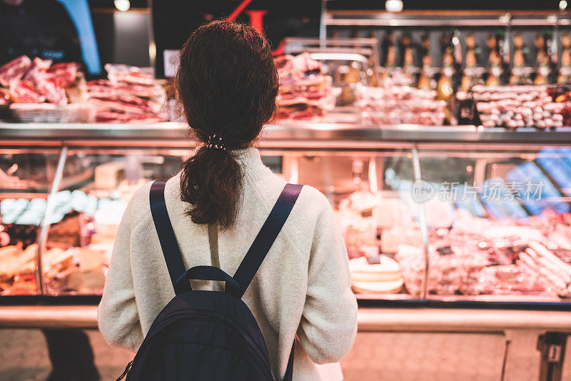 在肉店小摊上挑肉的女人