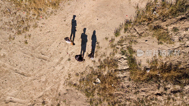 三个人的影子从无人机的角度站在沙漠
