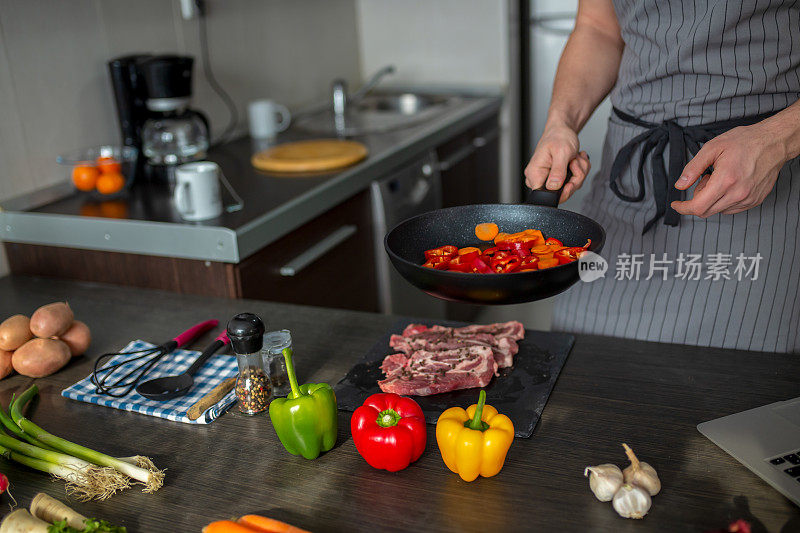 男人在厨房的桌子上切新鲜的春天蔬菜，特写。准备家庭食物，家庭厨房内部。