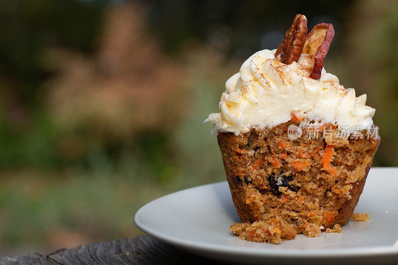 胡萝卜蛋糕纸杯蛋糕与奶油芝士糖霜与秋天的背景