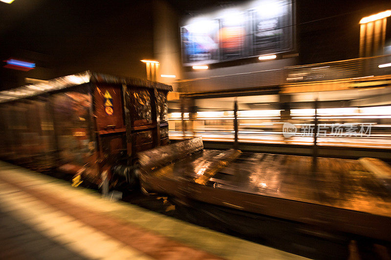 一列货运列车在夜间飞驰过火车站
