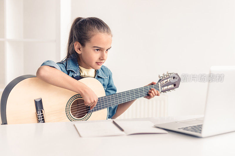 小女孩在网上学弹吉他