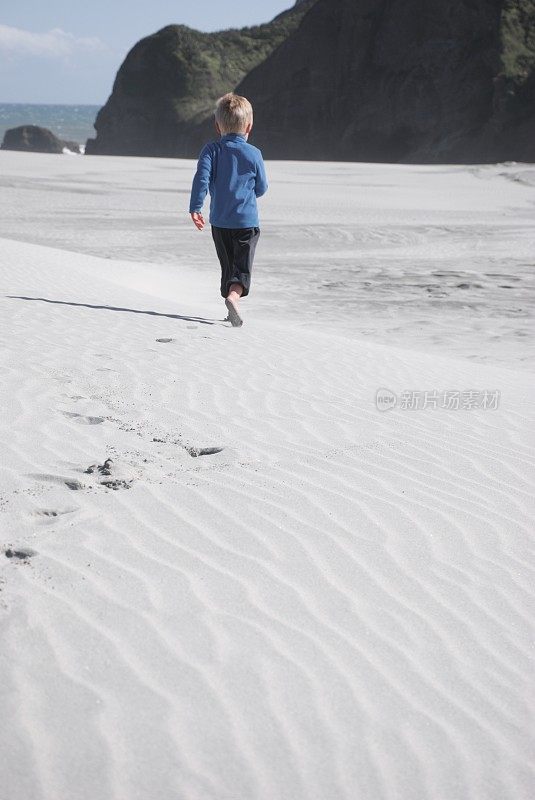 学龄前儿童冬天在海滩上跑步