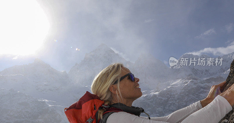 女登山家攀登雪坡，在山上