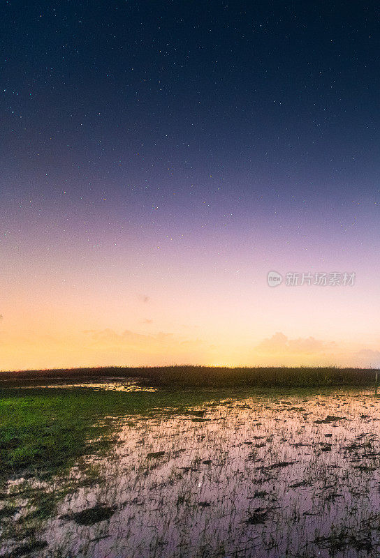 山上有银河和粉红的光。晚上多彩的景观。夏天的星空和山峦。美丽的宇宙。太空背景与星系。旅游的背景