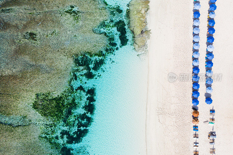 海滩伞和蓝色的海洋。从上面看海滩景色