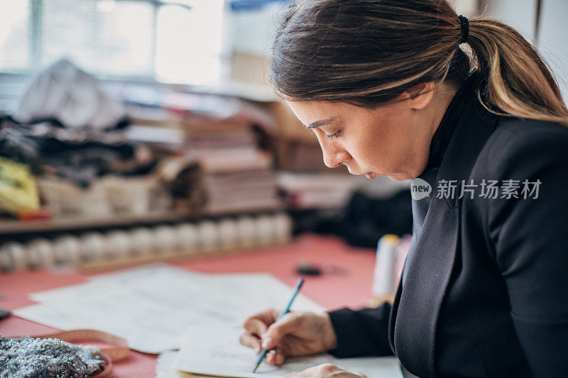 一位女时装设计师正在画新的时装素描