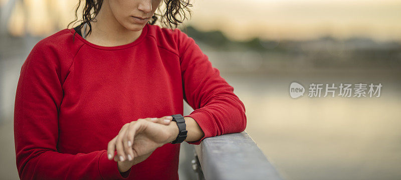 一个不知名的运动女性在智能手表上检查心率