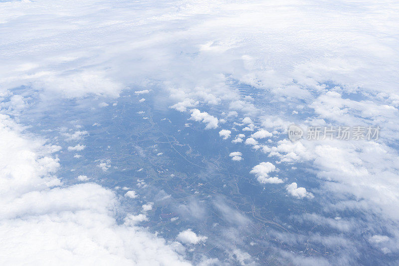 透过飞机窗口观看蓝天、白云和地面风景