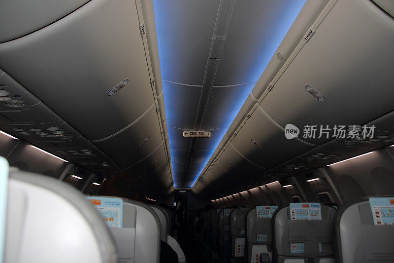 商用飞机的客舱，过道上有一排排的座位