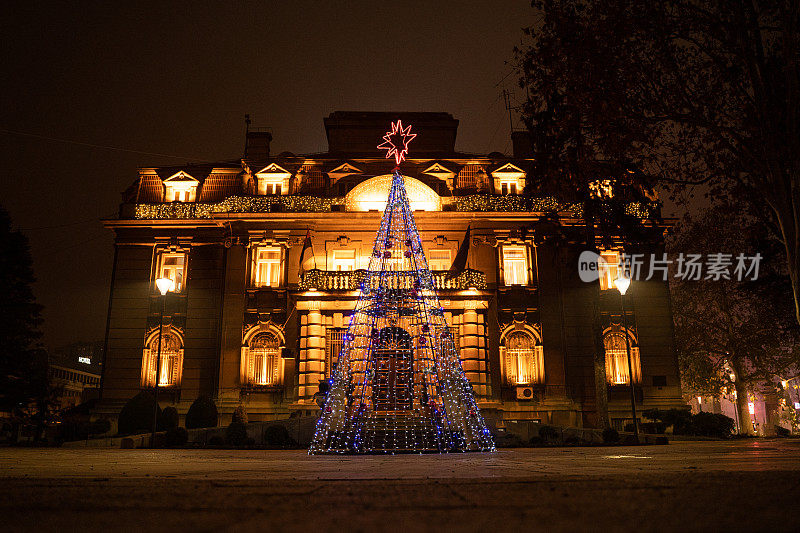 美丽的圣诞装饰形状的圣诞树和星星树顶部在一个联排别墅在晚上