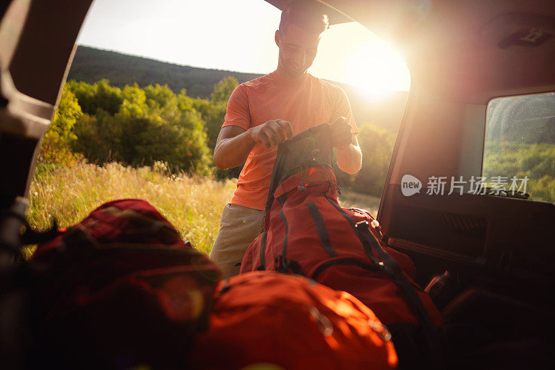 快乐的年轻人把登山装备装进背包里