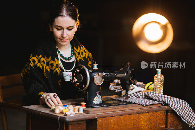 美丽的女人用一台古董缝纫机