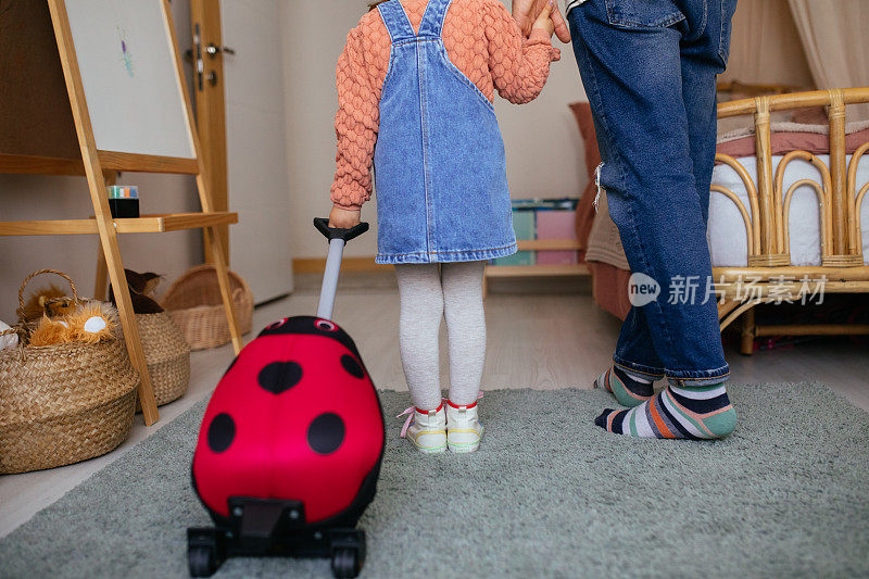 回到学校。父亲牵着家里背着背包的小女儿的手