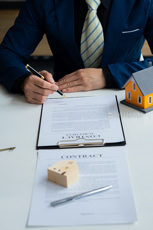 房屋销售代理在房地产公司向客户提供购房合同和保险。