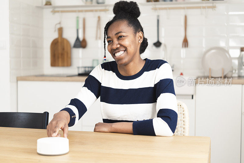 快乐的非洲裔美国女孩正在调整她家里的智能系统